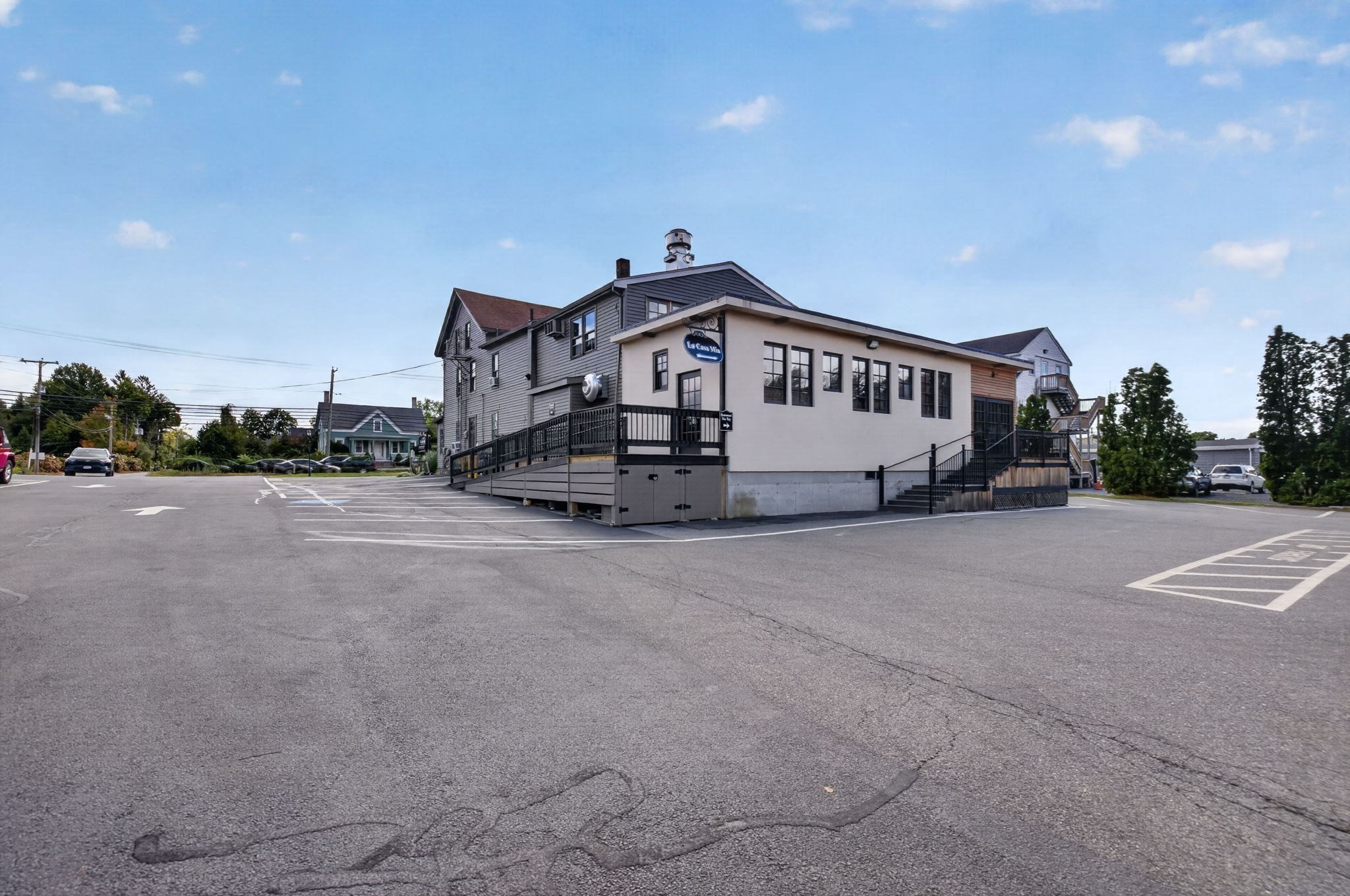 Commercial building with a La Casa Mia sign, raised deck, and broad paved parking lot.
