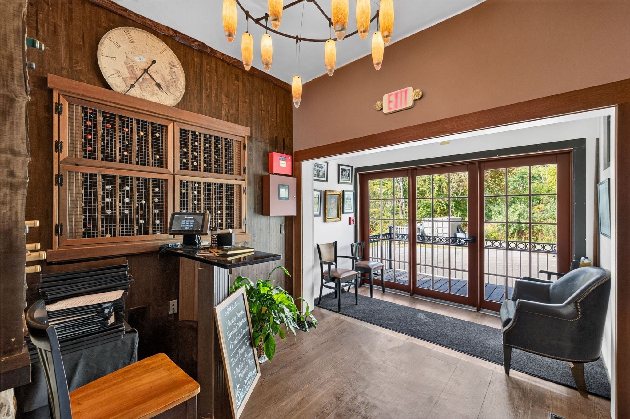 Commercial entry lobby with a wood reception counter and glass doors opening onto a deck.