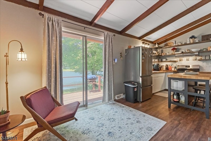 Kitchen and sitting area with exposed beams, sliding glass doors, and water views.