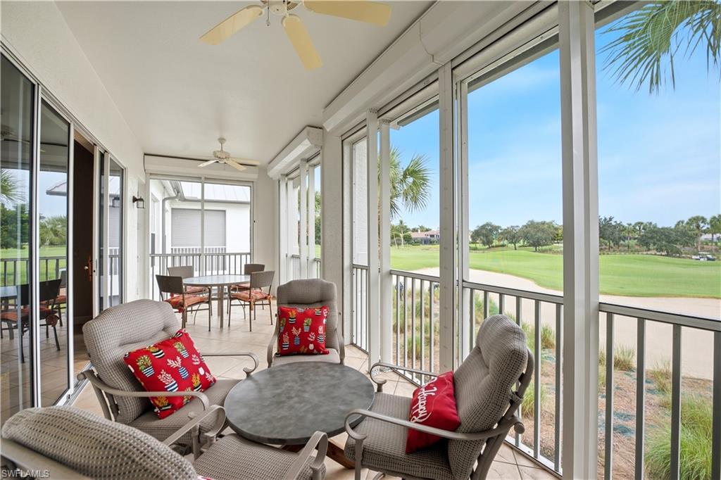 Furnished screened lanai with cushioned chairs and a golf course view.