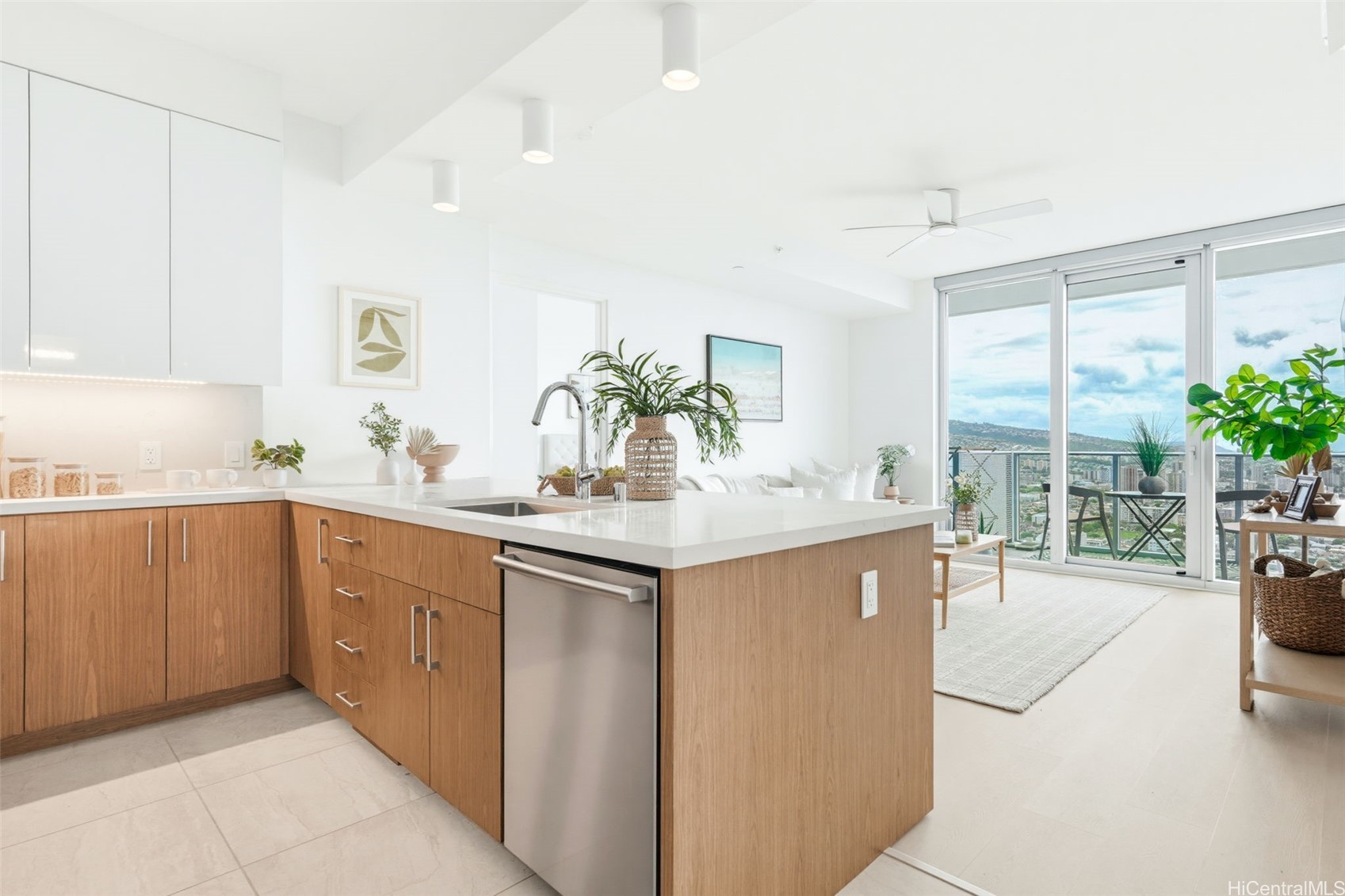 Modern kitchen with a large wood island and sliding doors opening to a balcony with city views.