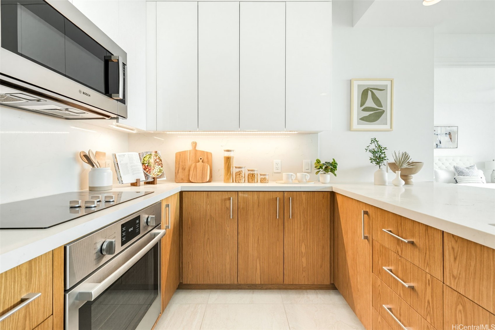 Bright kitchen with white countertops, warm wood cabinets, and stainless steel appliances.