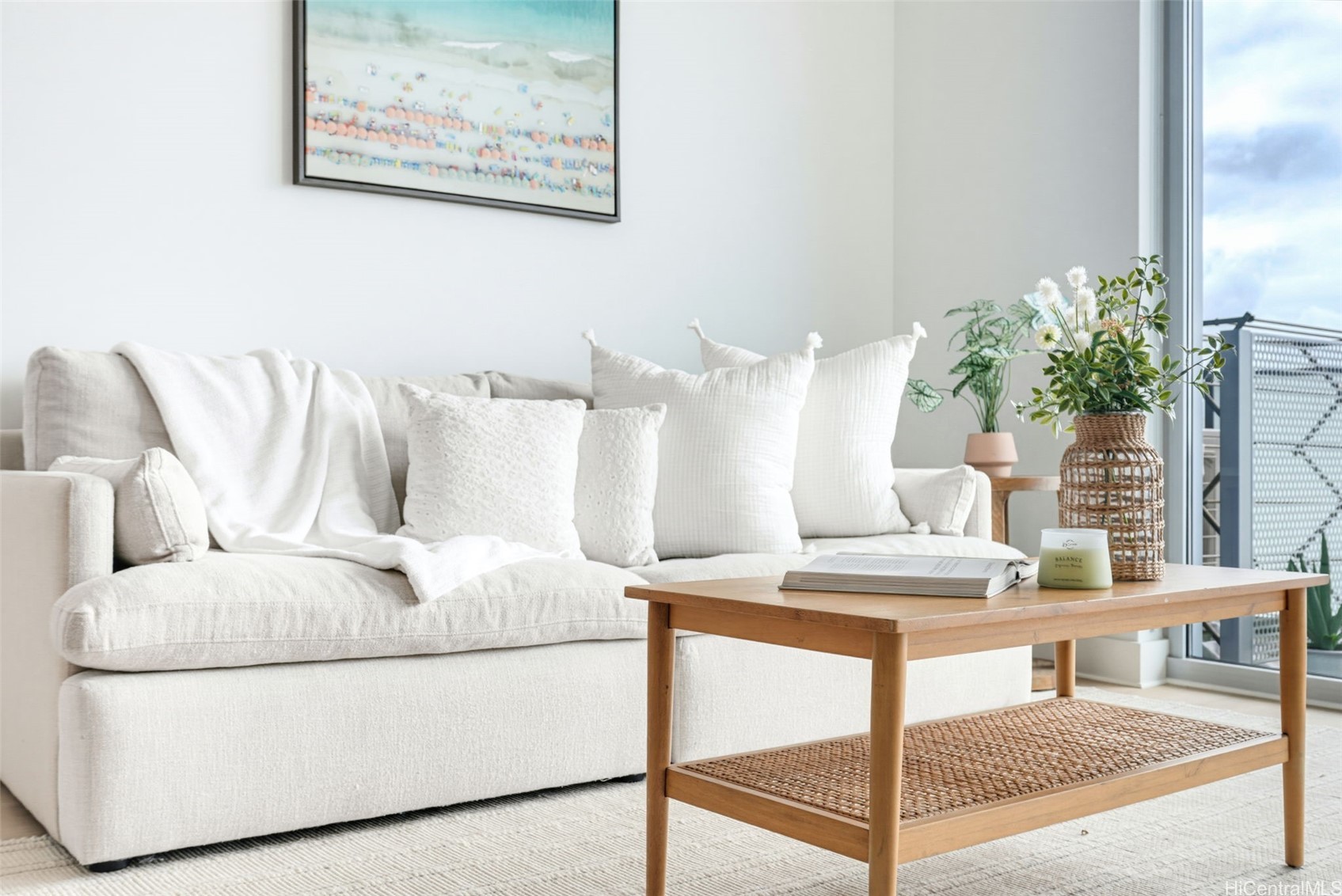 Bright living room with a white sofa, wooden coffee table, and sliding doors to a balcony.