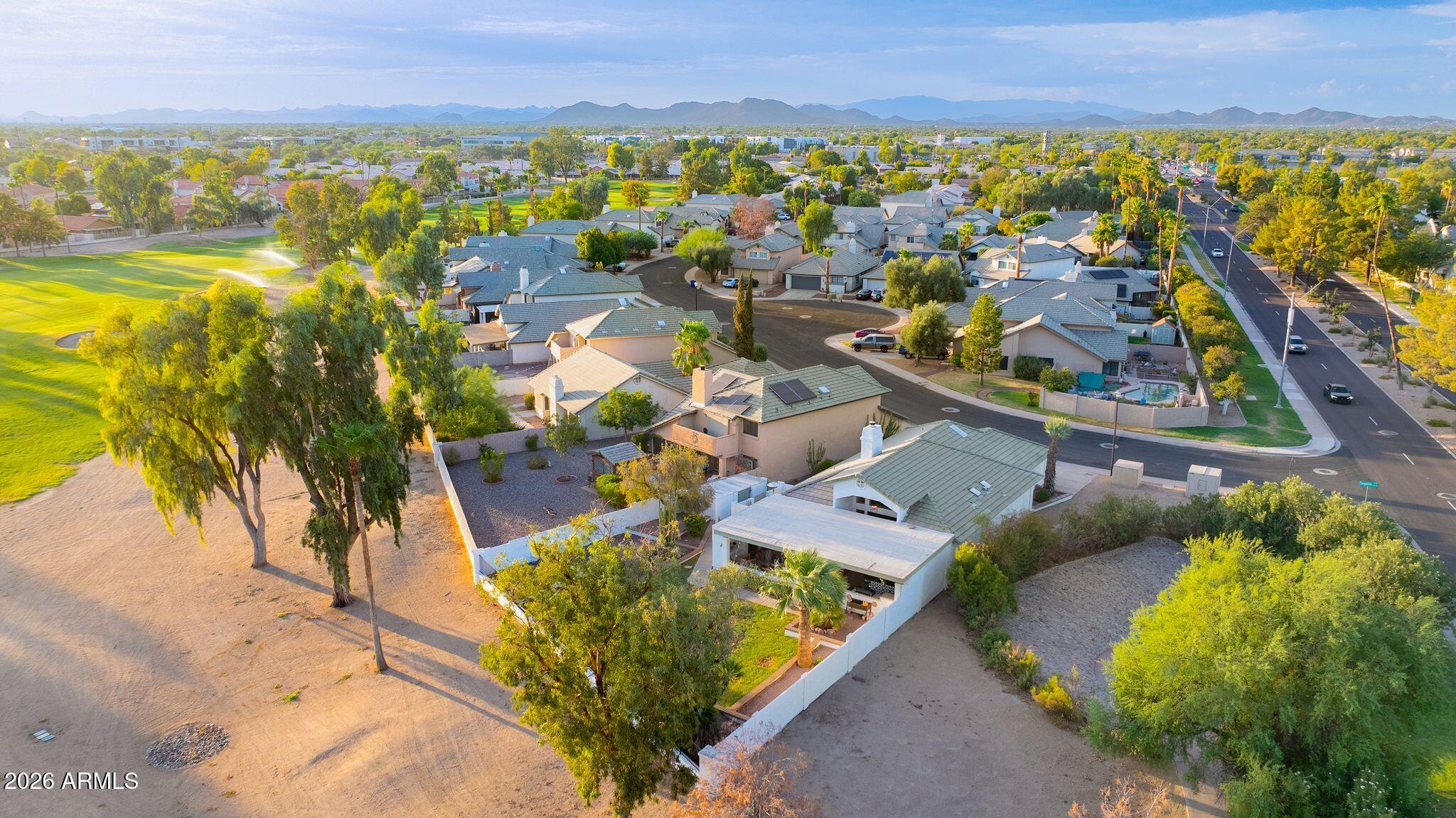 Aerial view of Glendale homes beside a green park, with mountains on the horizon.