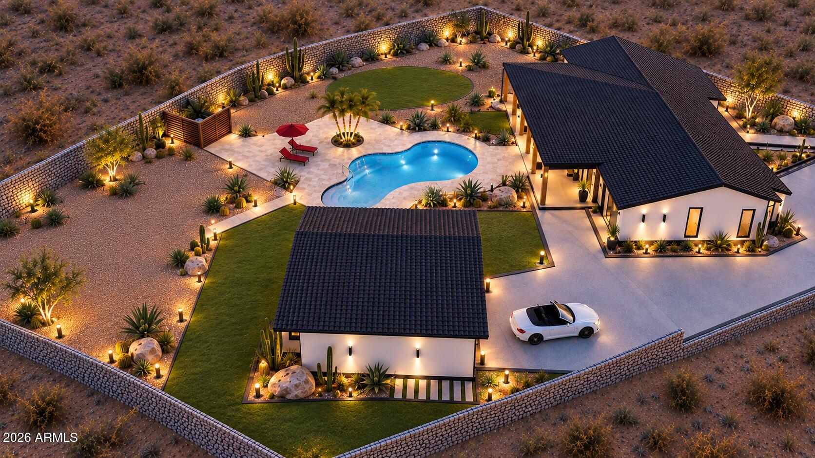 Aerial view of a modern Scottsdale home with a lit pool, landscaped yard, and stone perimeter wall.