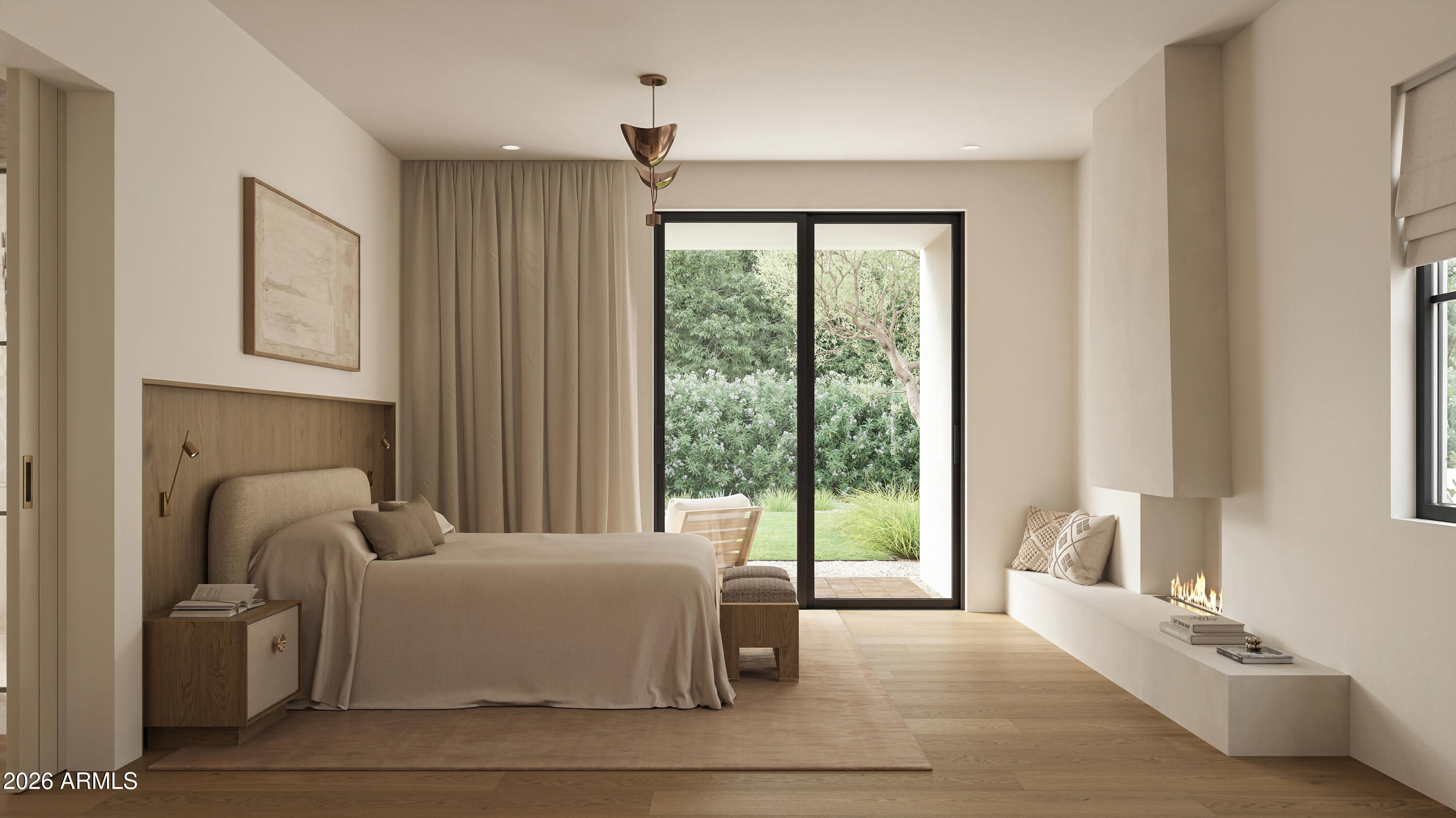 Staged bedroom with a modern fireplace and sliding glass doors overlooking a garden.
