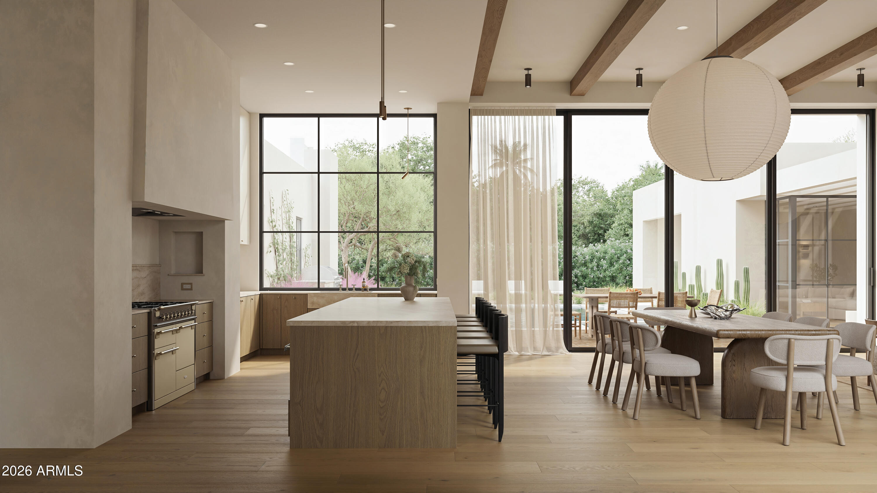 Open-plan kitchen and dining area with a wood island, exposed beams, and windows overlooking a cactus courtyard.