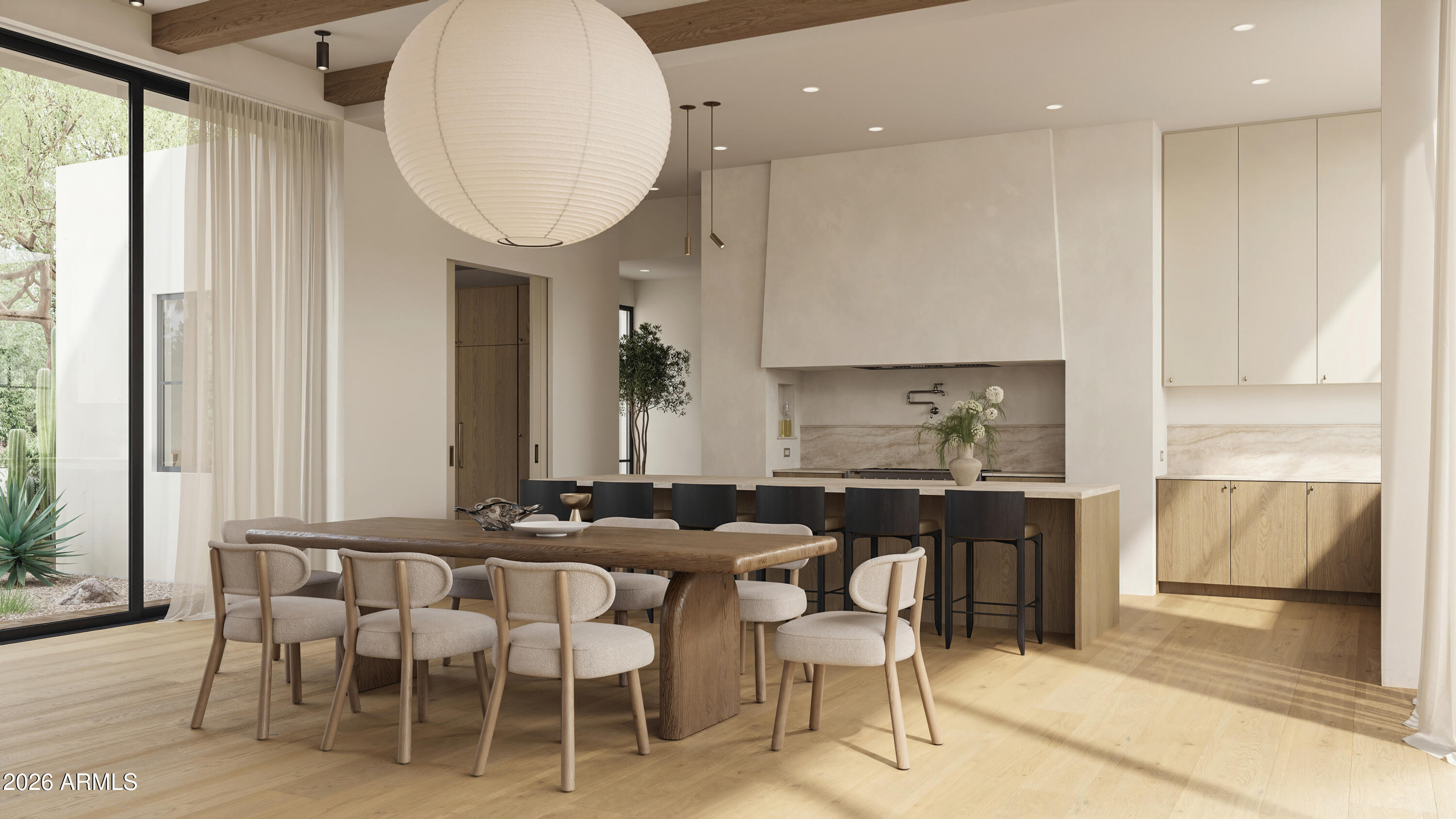 Open-plan dining room and kitchen with a long wood table, oversized pendant light, and island seating.