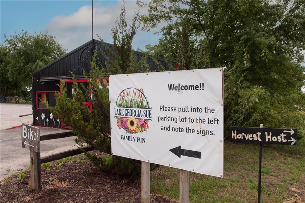 Entrance to Lake Georgia-Sue Family Fun, with a welcome sign beside a black, red-trimmed building.