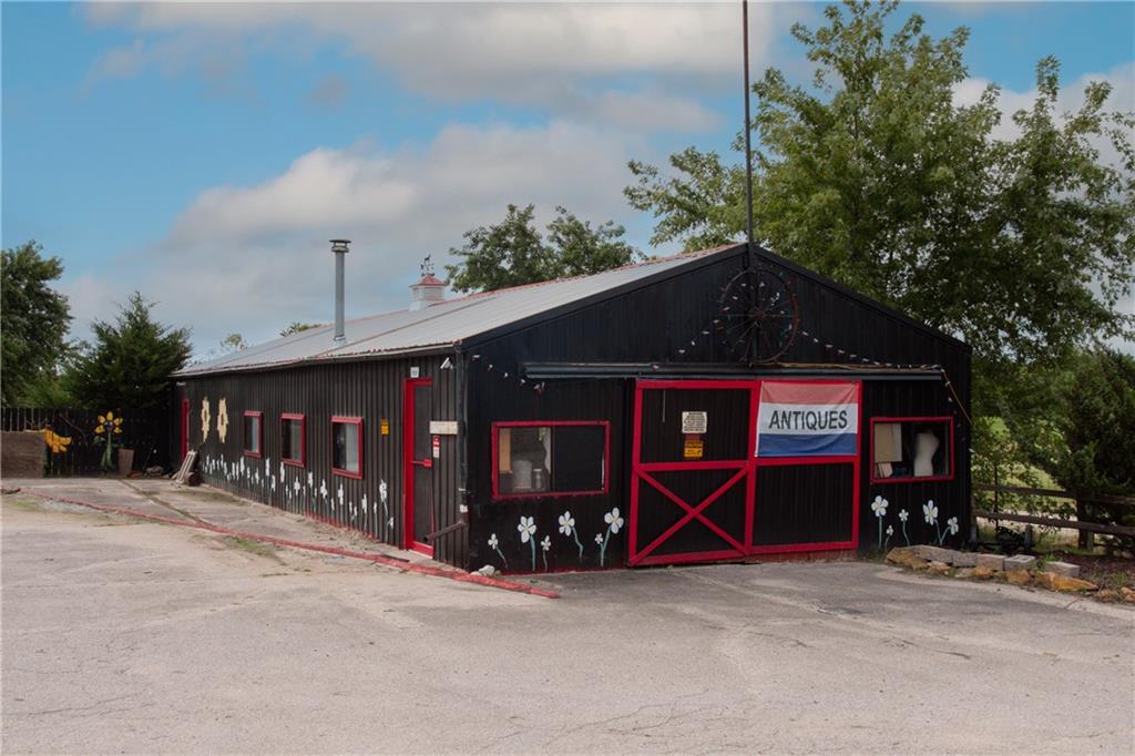 Black antiques shop with red trim, a silver roof, and a prominent antiques sign.