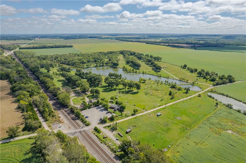 Aerial view of a rural property with ponds, fields, and railroad tracks.