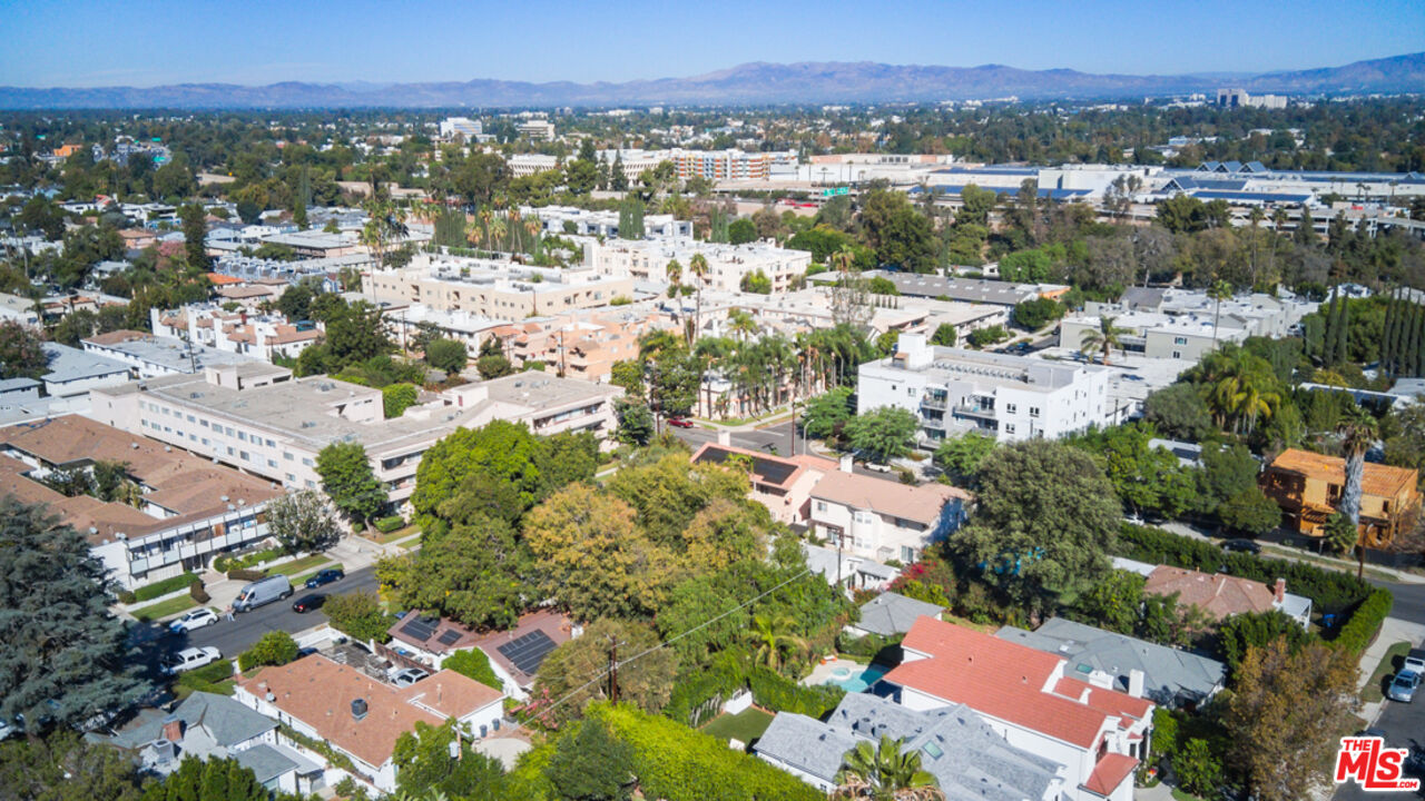 Aerial view of homes and apartment buildings, with distant mountains on the horizon.