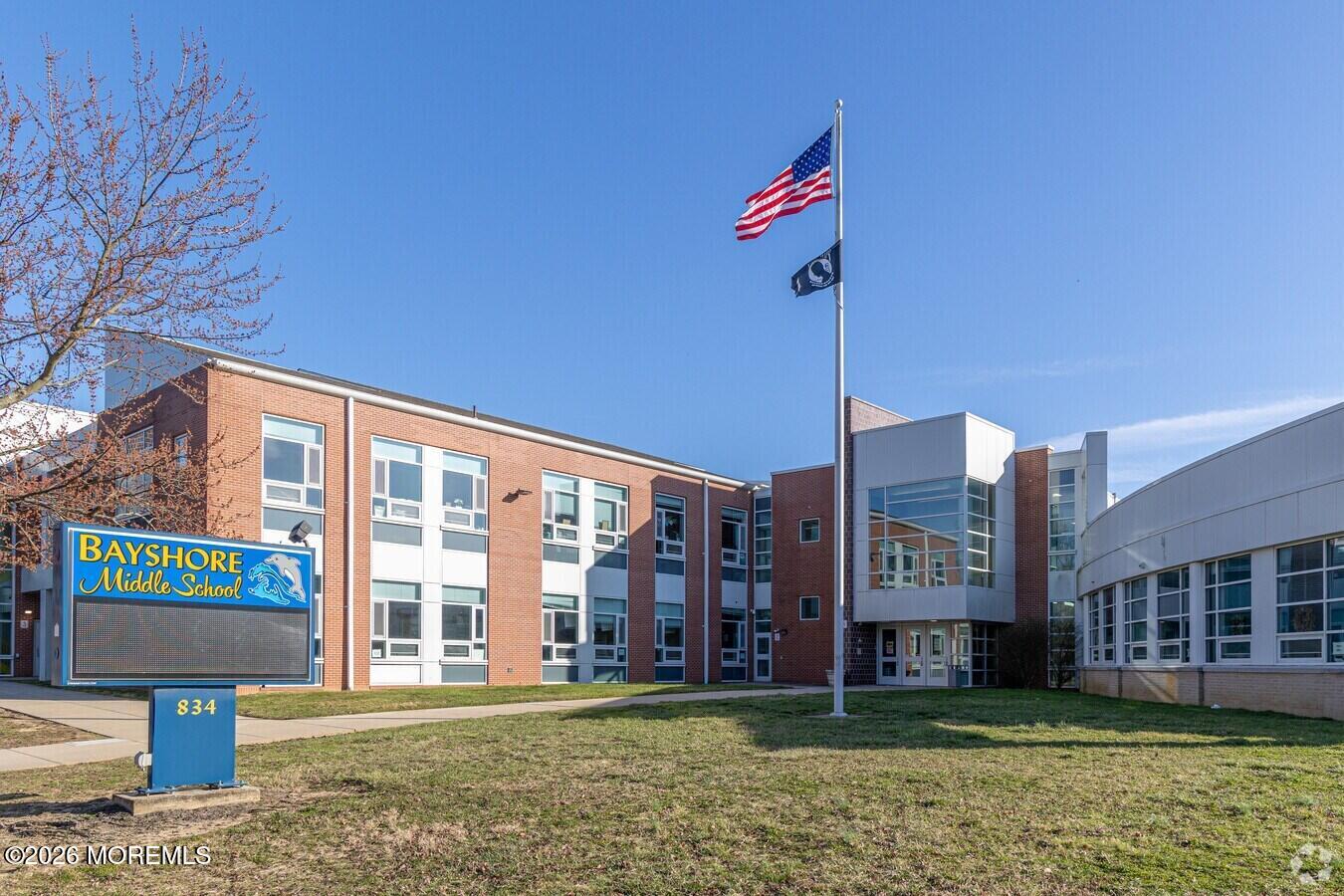 Bayshore Middle School exterior with its roadside sign and flags.