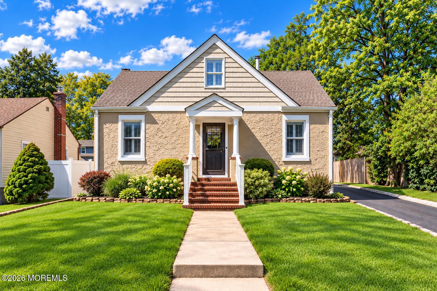 542 Clinton Avenue home with a steep front gable, brick steps, and a green landscaped lawn.