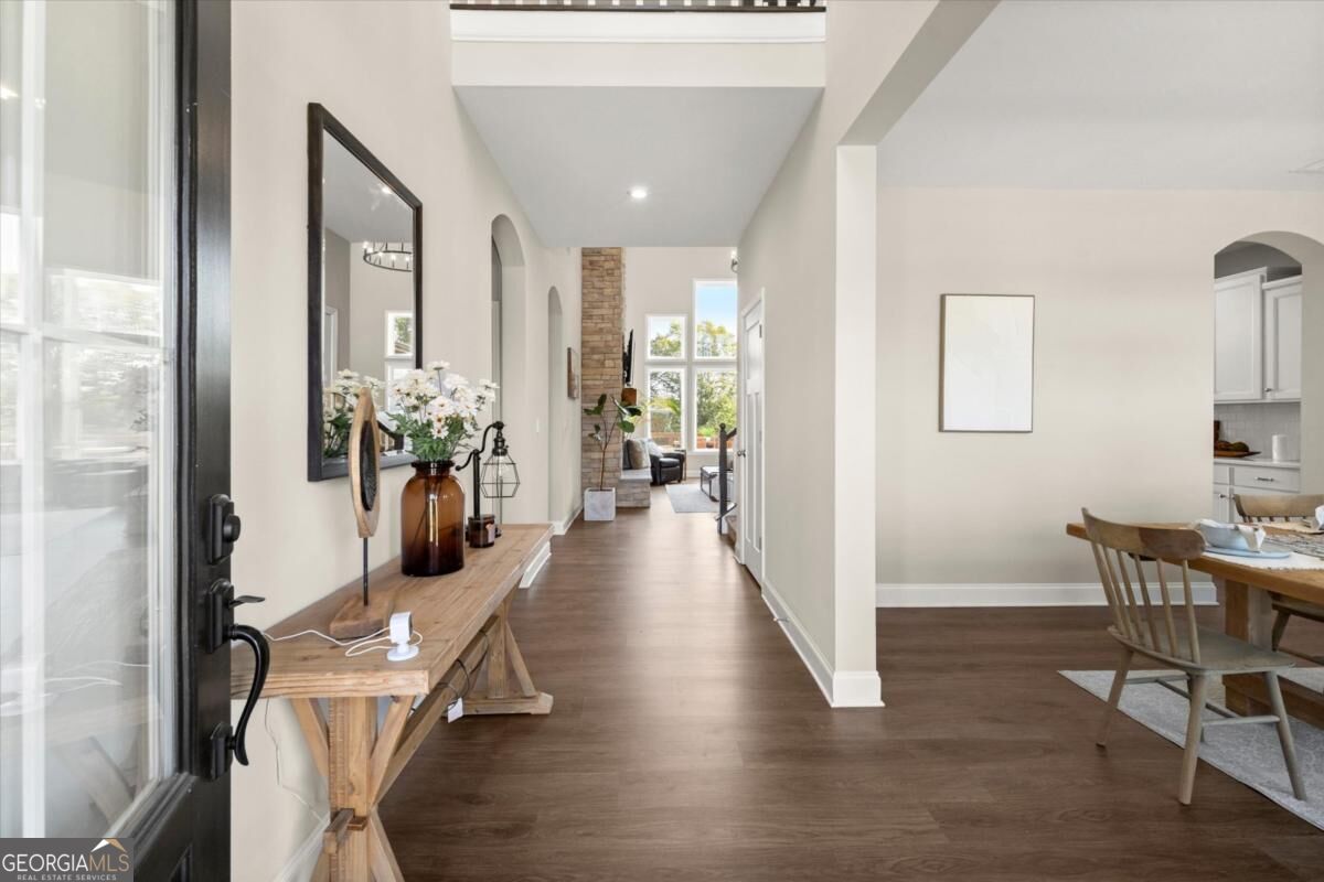 Furnished entry hall with a wood console table, opening to a living area and dining room.