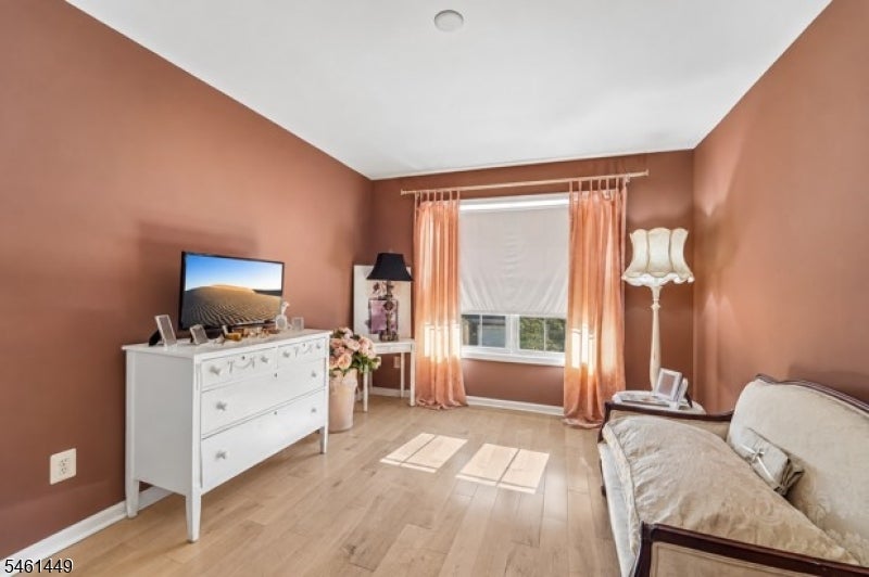 Bedroom with terracotta walls, peach curtains, a white dresser, and a sofa or daybed.