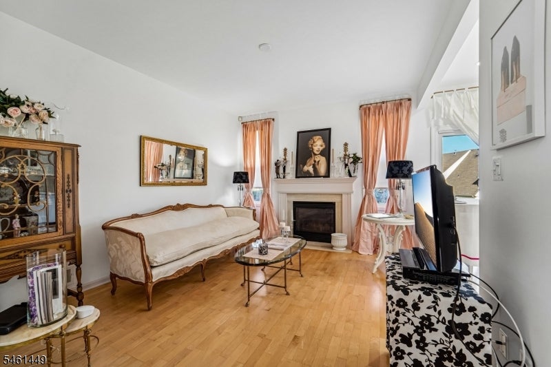 Living room with a cream sofa, fireplace, and warm hardwood floors.