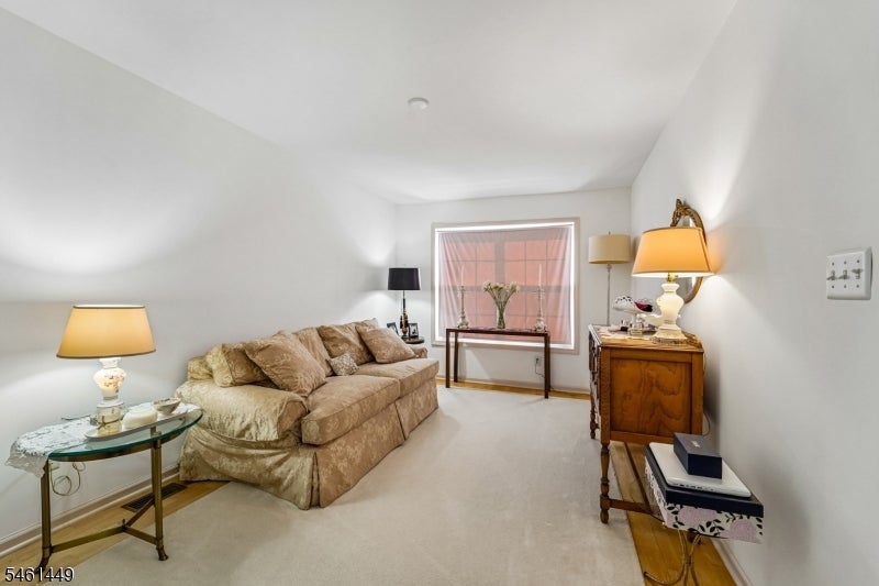 Living room with a beige sofa, cream carpet, and traditional wooden furniture.
