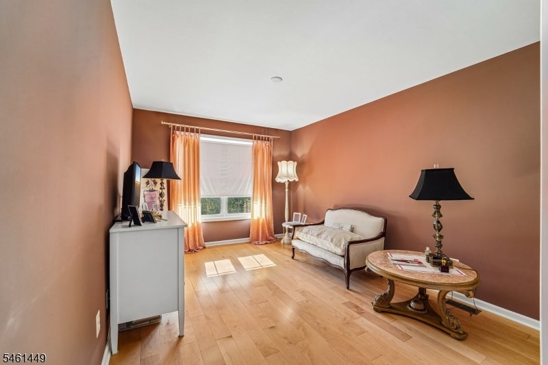 Sitting room with terracotta walls, a curtained window, and an upholstered settee.