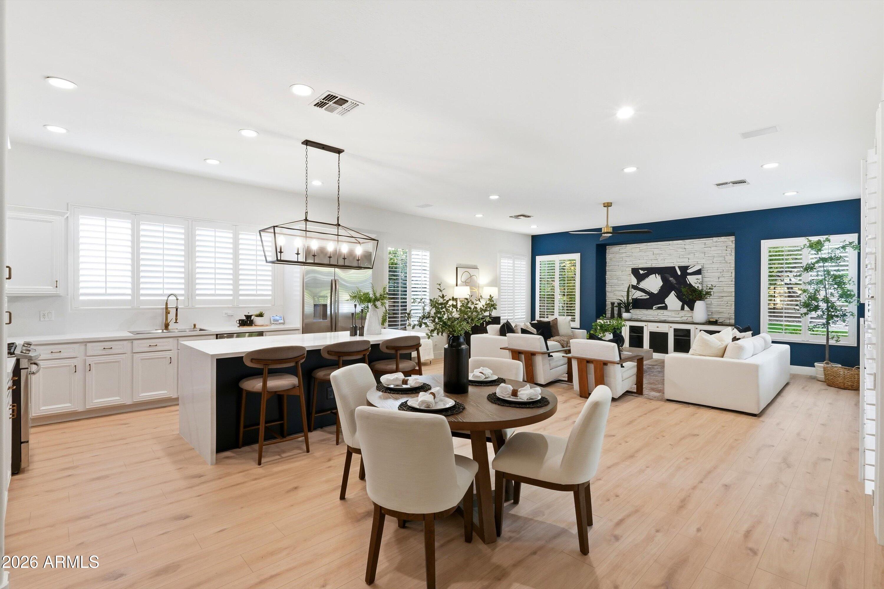 Open-plan kitchen, dining area, and living room with a large island and navy accent wall.