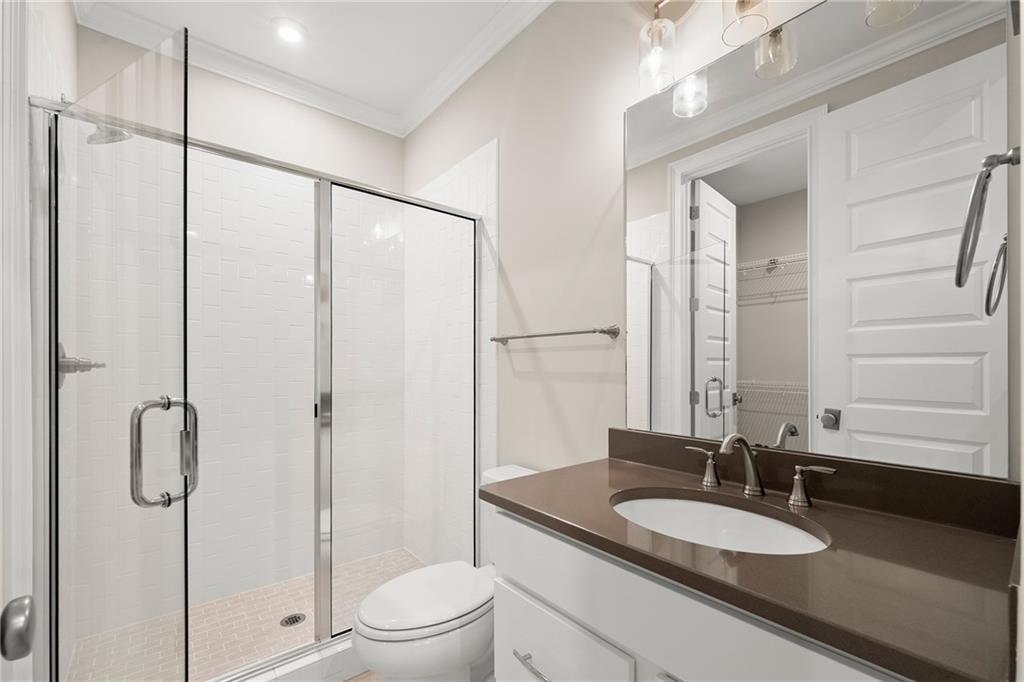 Bathroom with a glass-enclosed shower and white vanity topped with a dark countertop.
