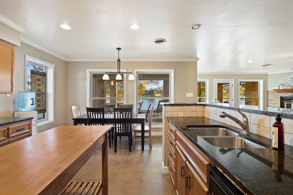 Kitchen and dining area with wood cabinets, a butcher-block island, and windows overlooking the yard.