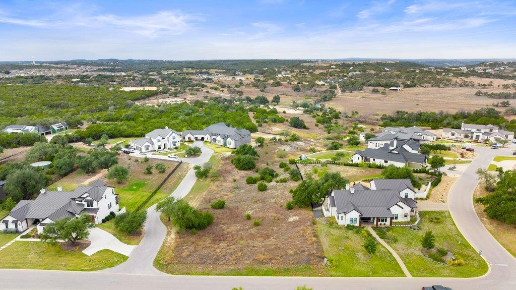 Aerial view of a vacant lot between homes along a residential road.
