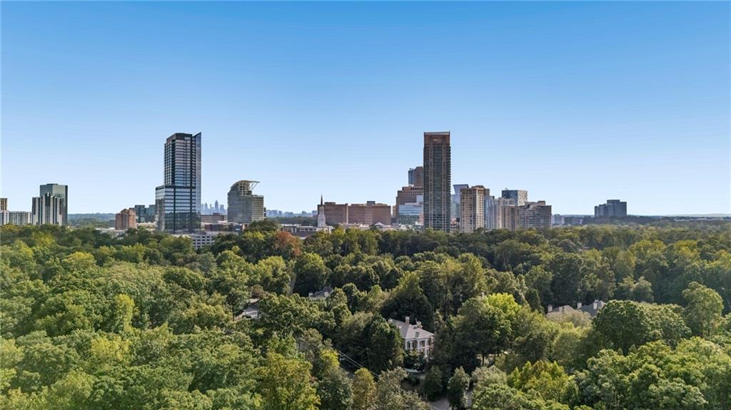 Atlanta skyline rises above a leafy canopy of trees and homes.