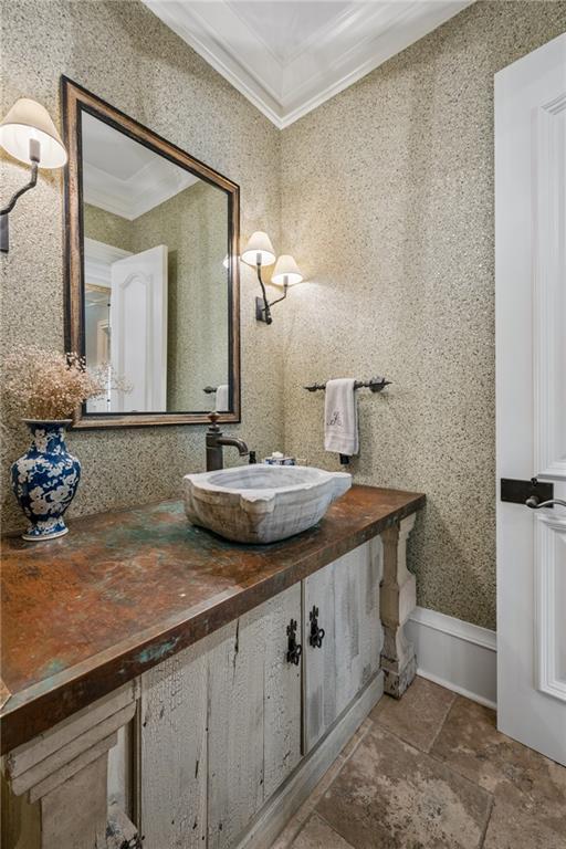Bathroom vanity with a stone vessel sink, mottled countertop, and large framed mirror.