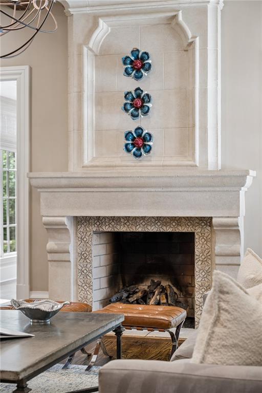 Living room fireplace with patterned tile, a stone mantel, and three blue floral ornaments.