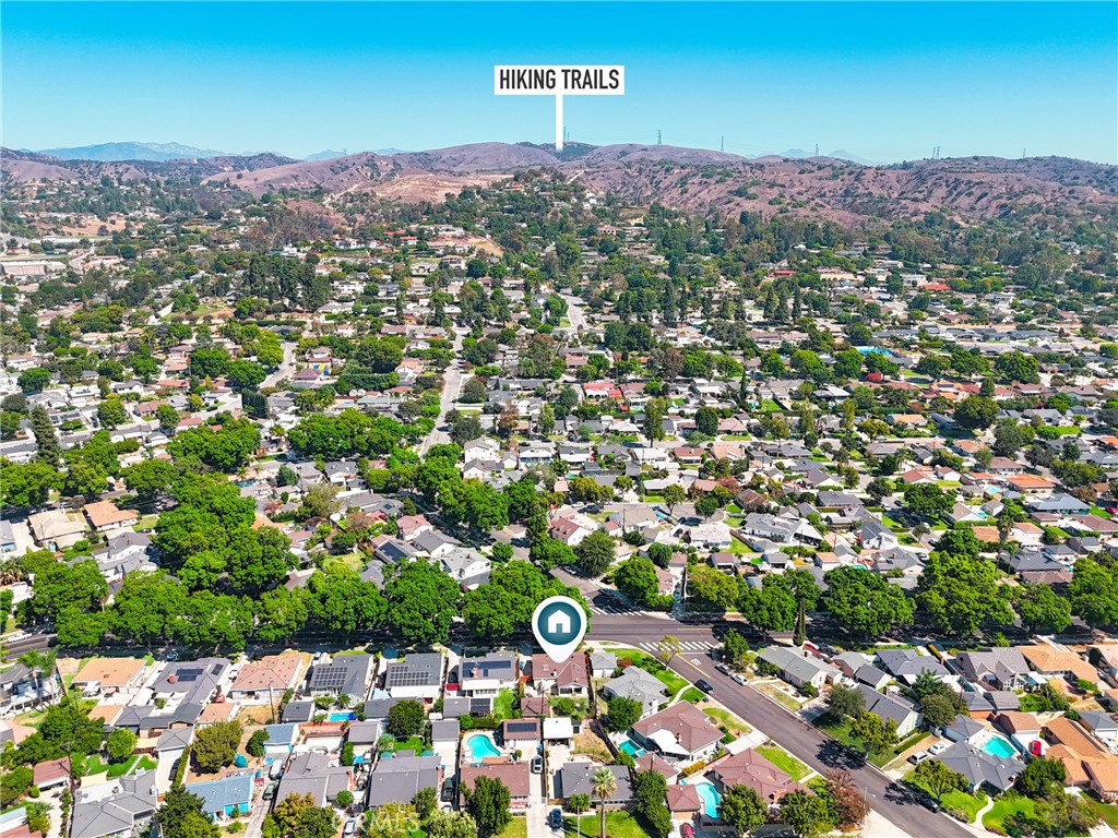 Aerial view of the home’s neighborhood, with green tree-lined streets and hiking trails in the nearby hills.
