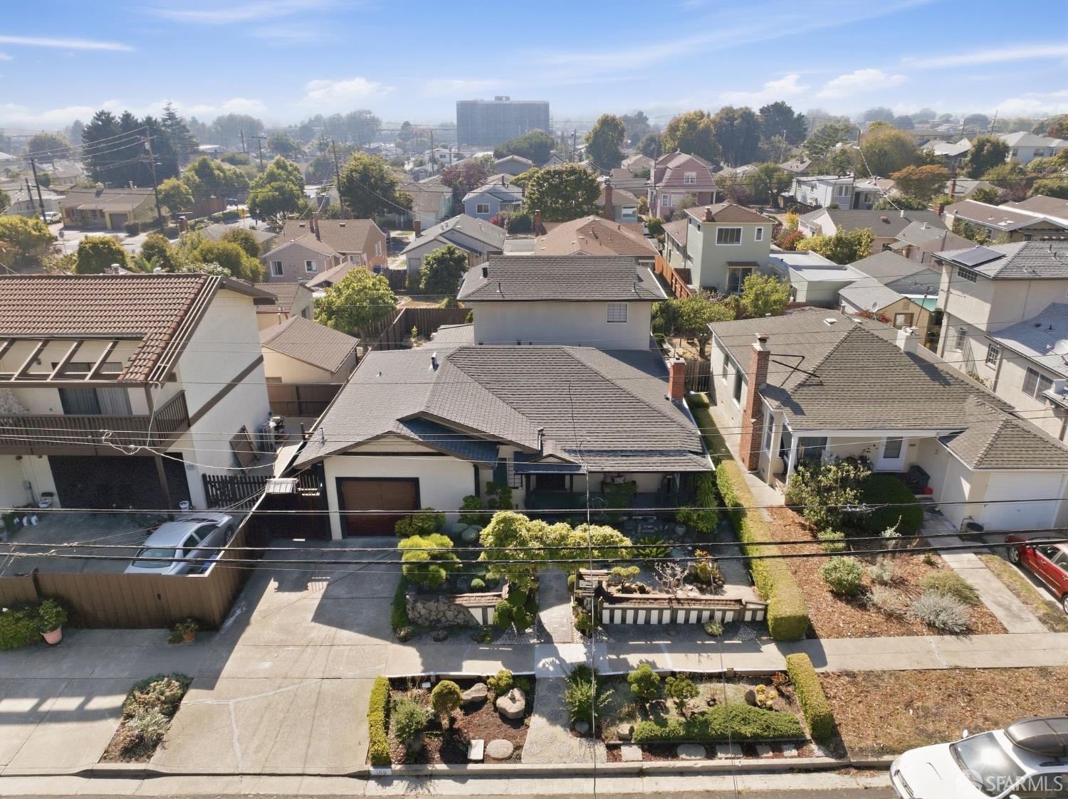 Aerial view of 509 Clayton Avenue, with its gray roof and landscaped front garden among neighboring homes.