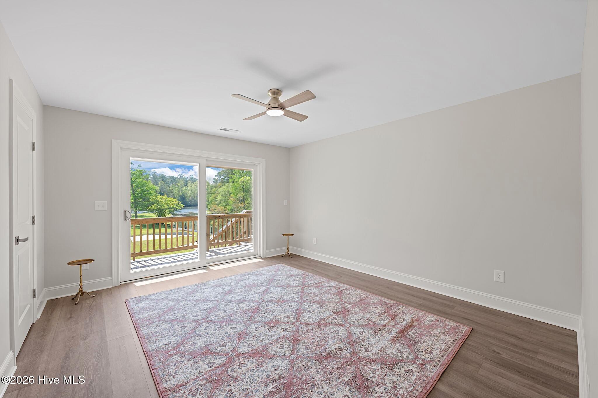 Bright room with a patterned rug and sliding doors opening onto a deck.