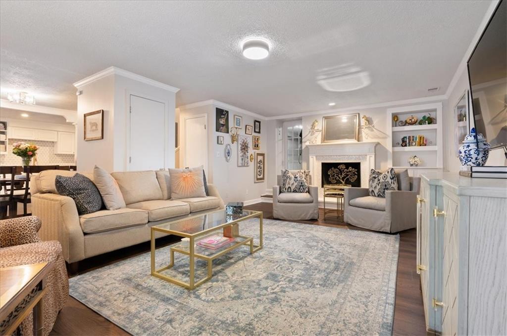 Living room with a beige sofa, patterned rug, built-in shelves, and fireplace.
