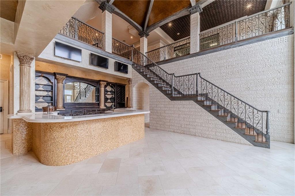 Grand interior with a curved bar and sweeping wrought-iron staircase.
