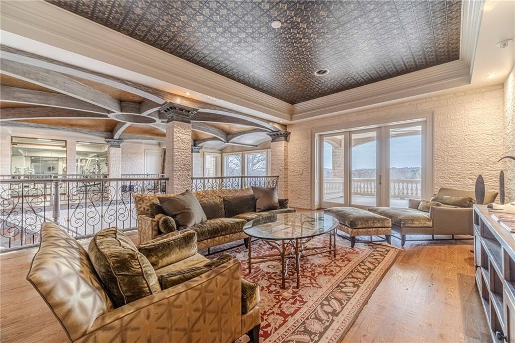 Living room with ornate ceiling, patterned rug, and glass doors opening to a balcony.