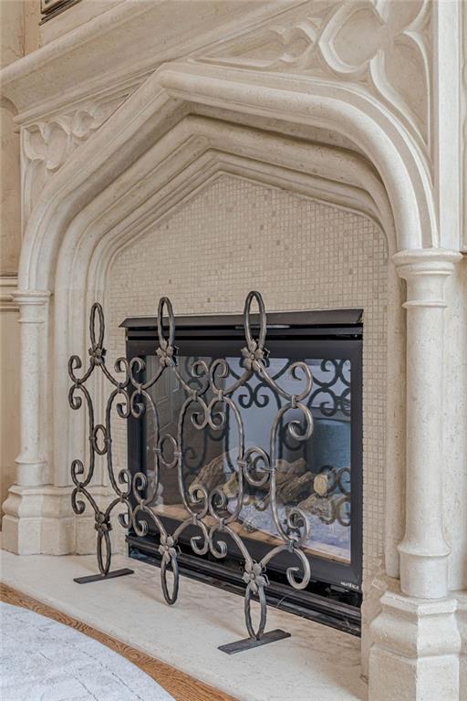 Ornate stone fireplace with a tiled inset and decorative wrought-iron screen.
