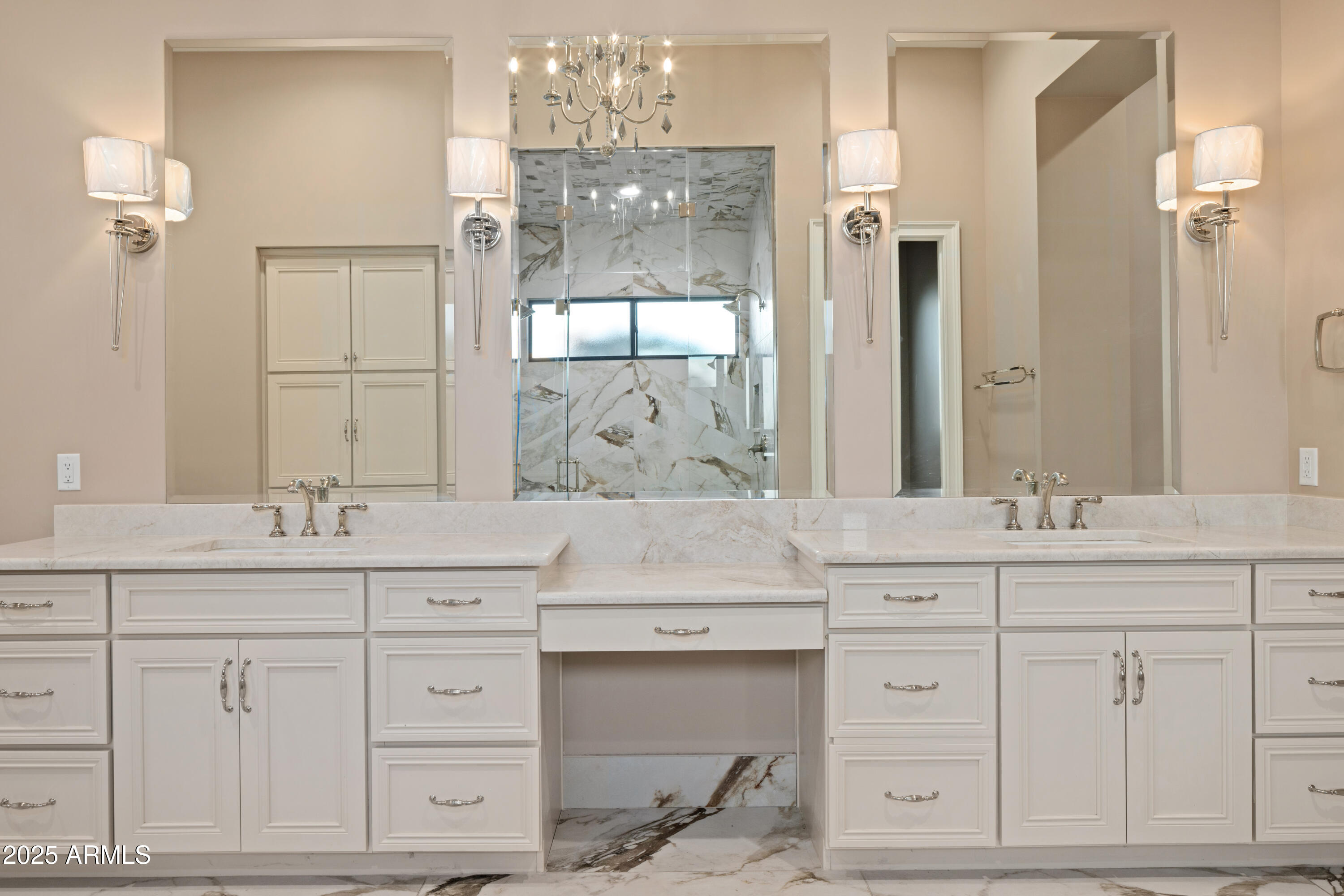 Bathroom with a long double vanity and a glass-enclosed marble shower.