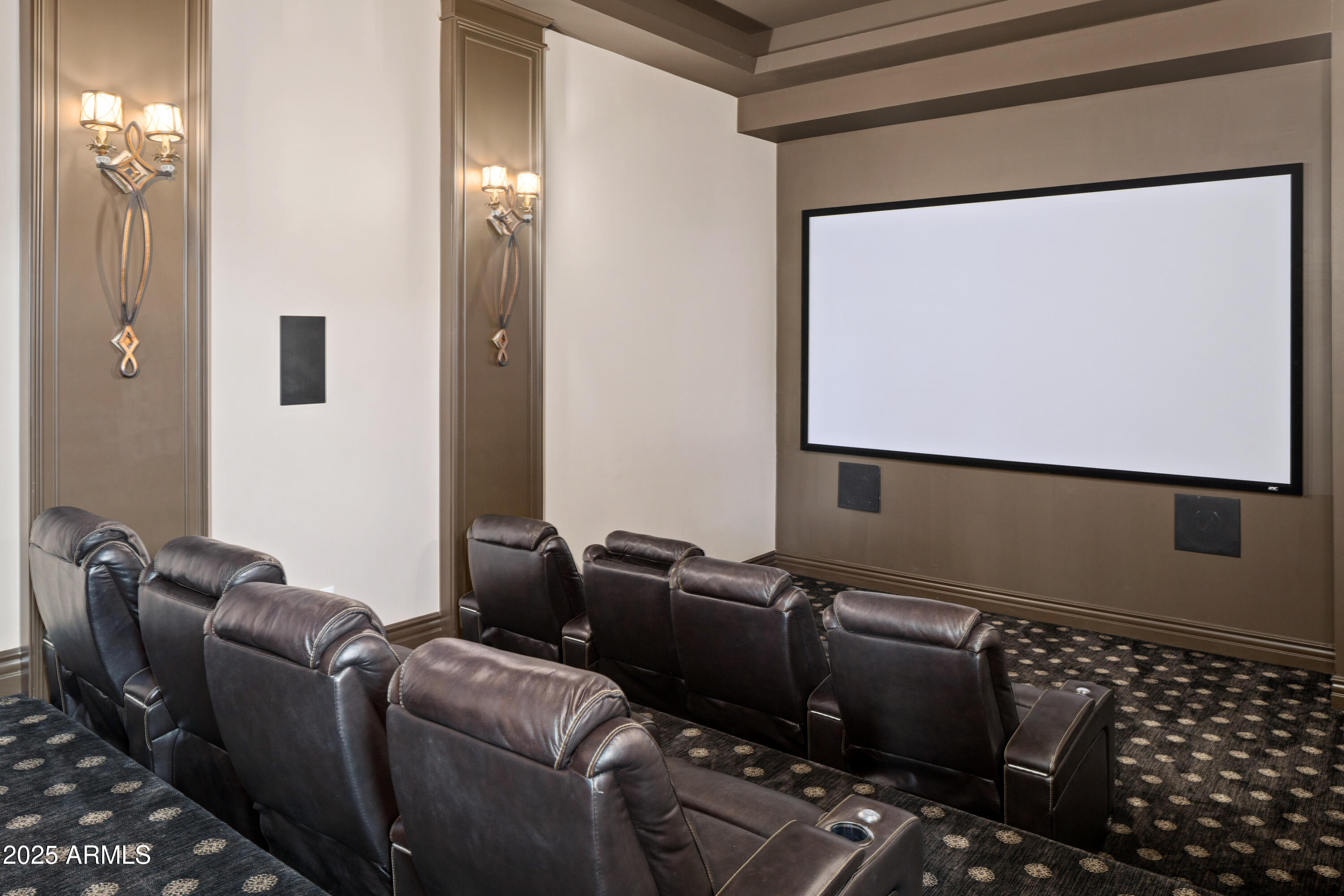 Home theater with dark leather recliners facing a large projection screen.