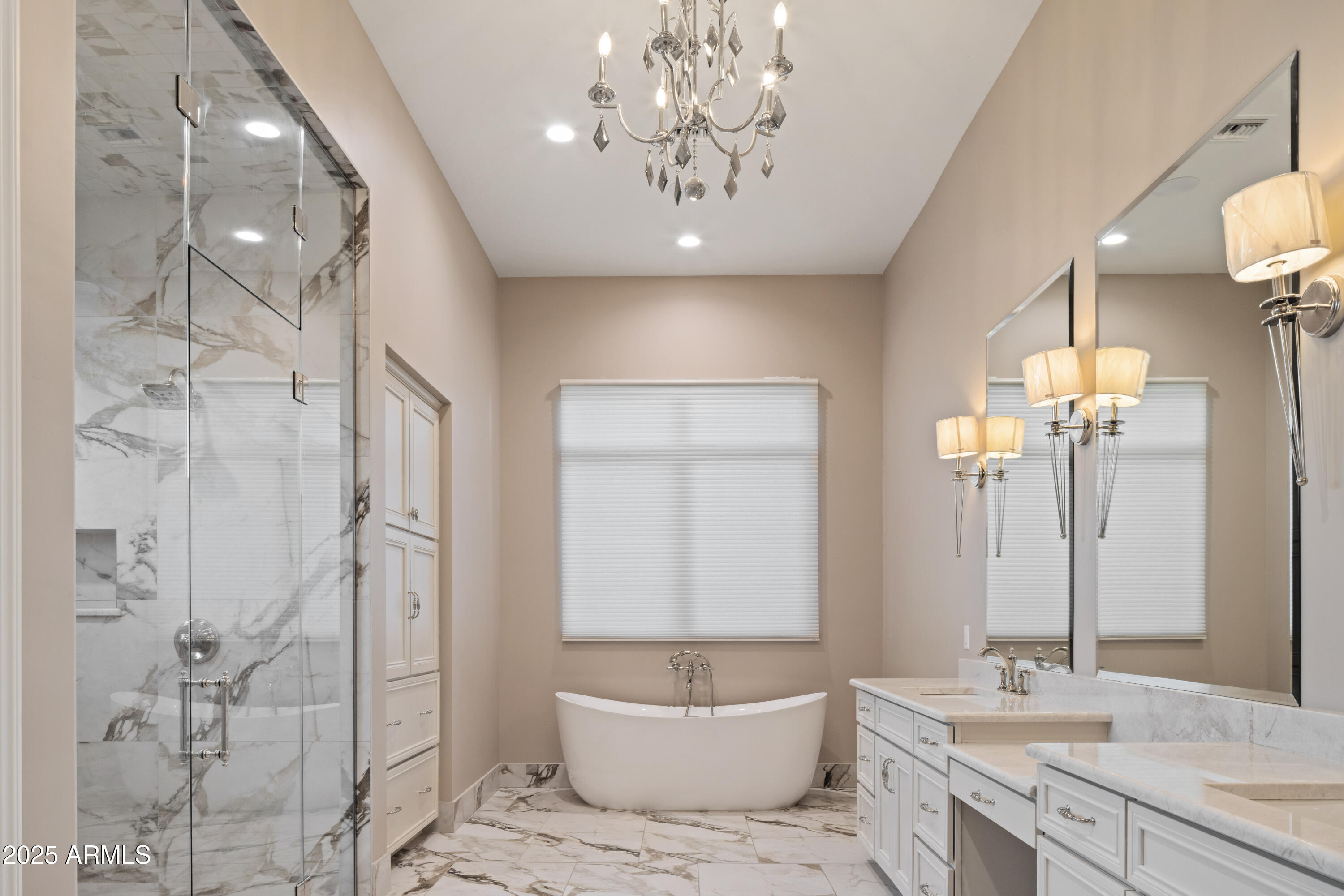Bathroom with a freestanding tub, marble shower, and long double vanity.