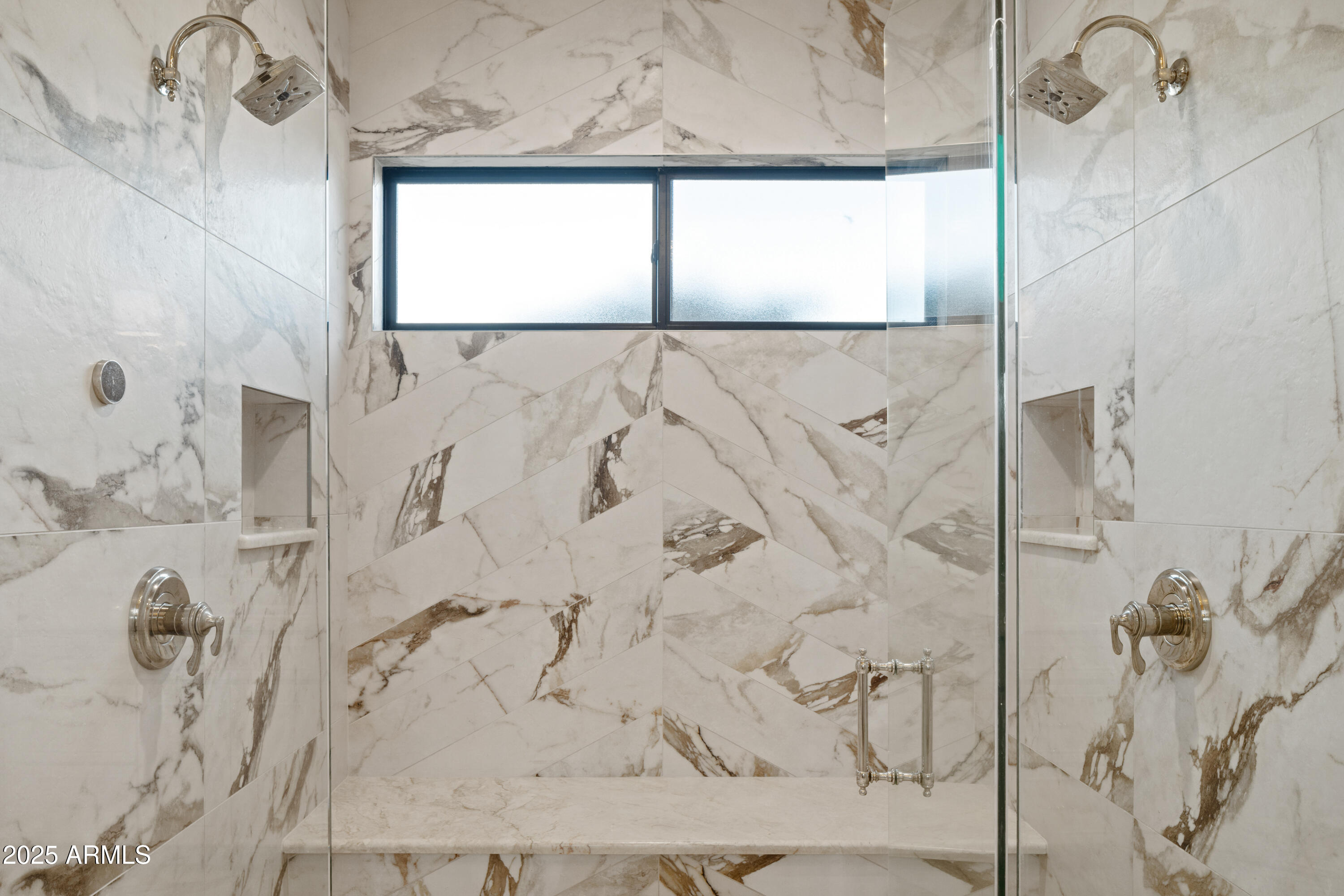 Marble walk-in shower with glass enclosure, dual showerheads, and a wide frosted window.