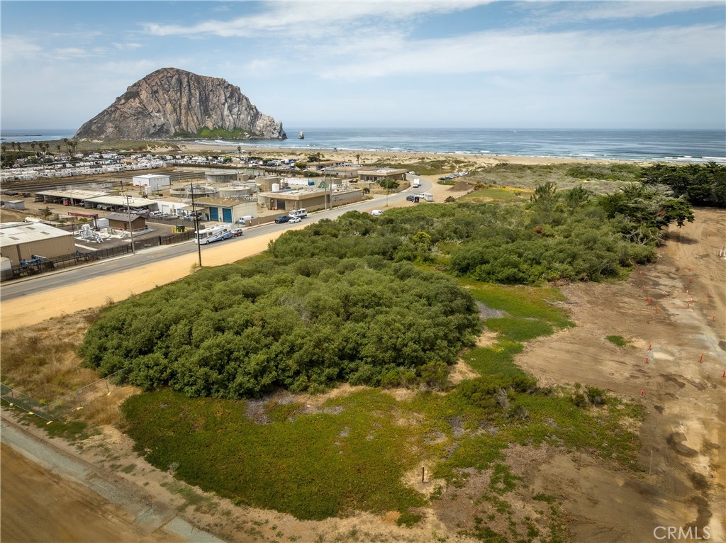 Aerial view of vacant coastal land near Morro Bay, with Morro Rock and the ocean beyond.