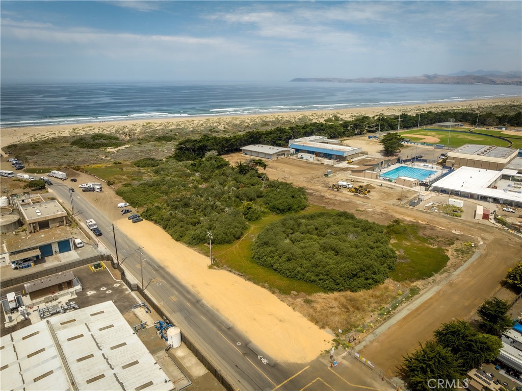 Aerial view of coastal land beside Atascadero Road, with ocean shoreline and nearby sports facilities.