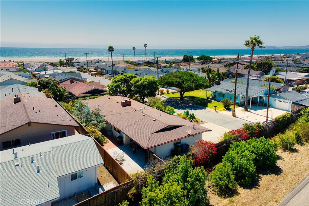 Coastal homes with the beach and Pacific Ocean beyond, viewed from above.