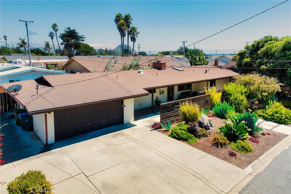 Single-story home with a wide driveway, attached garage, and landscaped front yard.