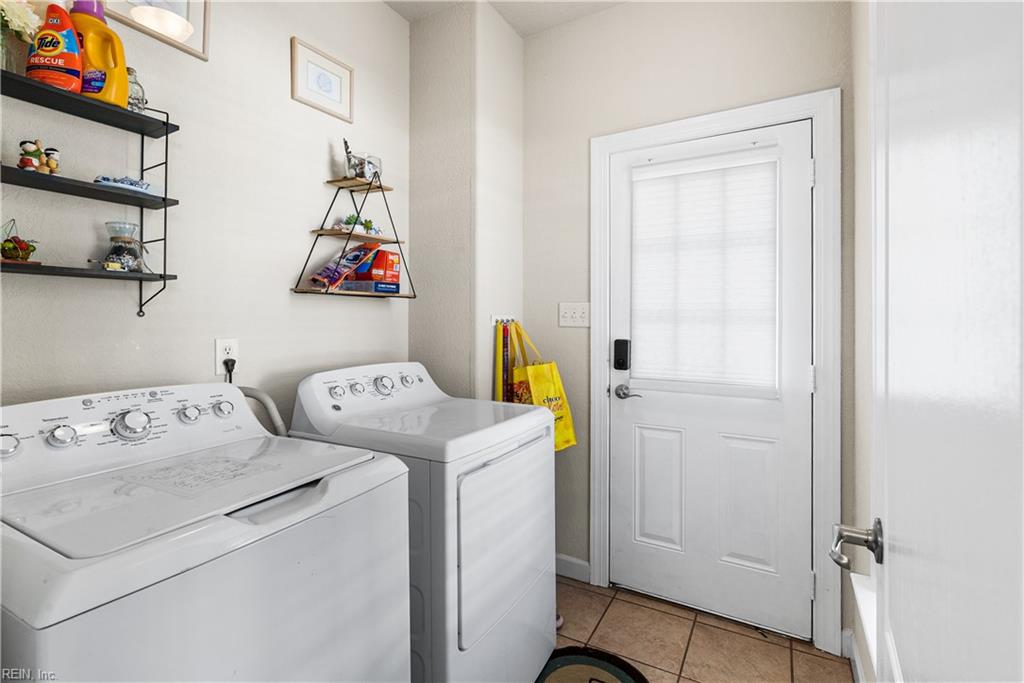 Laundry room with a white washer and dryer beside a windowed exterior door.