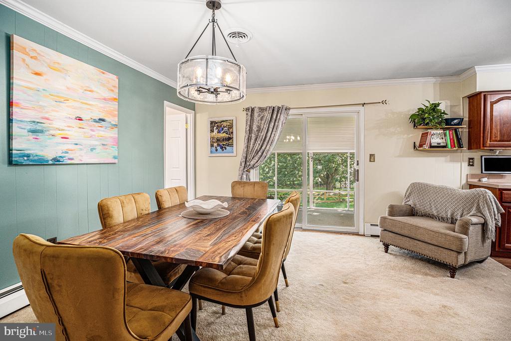 Dining and living area with a wood table, teal accent wall, and sliding glass door to the yard.
