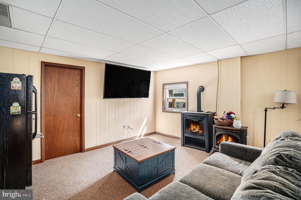 Living room with a gray sectional, wooden coffee table, and two freestanding fireplaces.