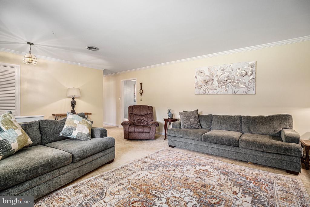 Living room with gray sofas, a brown recliner, and a patterned area rug.