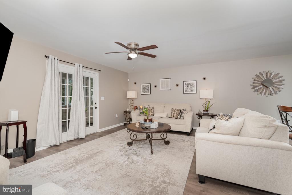 Living room with cream sofas, French doors, and a pale area rug.